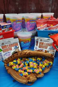 a table topped with lots of different types of candy and snacks in buckets next to each other