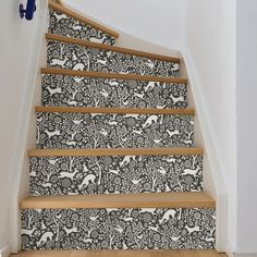 the stairs are decorated with black and white wallpaper, which has deers on them