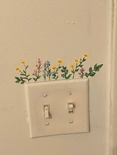 a light switch with flowers painted on it