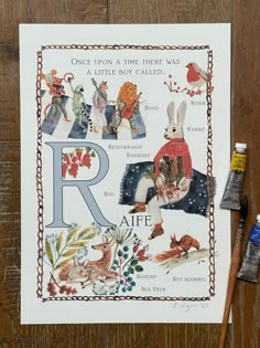 a card with the letter r on it next to paintbrushes and watercolors