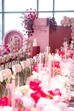 the tables are set up with pink and white flowers, candles, and balloon decorations