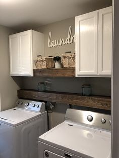 a washer and dryer in a small room with white cabinetry on the wall