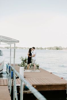 a man and woman standing on a dock kissing