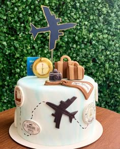 a cake that is sitting on top of a table with an airplane and some luggage