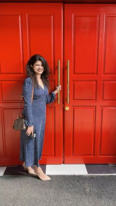 a woman standing in front of a red door