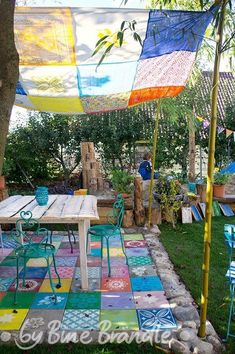 an outdoor area with colorful rugs and tables