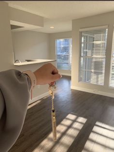 a hand holding a key in an empty room