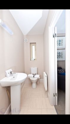 a bathroom with a toilet, sink and mirror in it's center wall is shown