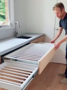 a man standing next to a bed in a room