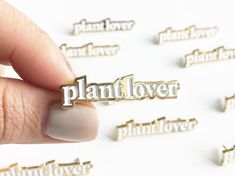 the word plant lover is being held by someone's finger