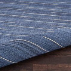 a blue rug on top of a wooden floor next to a wood flooring board