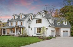 a large white house sitting on top of a lush green field