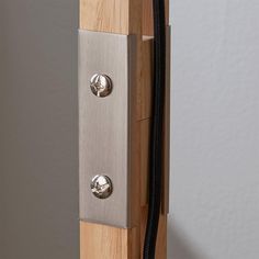 a close up view of a door handle on a wooden post with two metal knobs