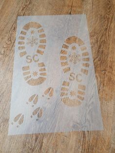 a piece of wood with footprints on it and snowflakes drawn on the floor