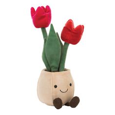 a stuffed flower pot with two red tulips in it and a smiling face