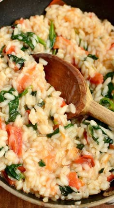 a skillet filled with rice and vegetables on top of a wooden table