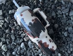 an upside down view of a cup on some rocks and gravel with the lid off