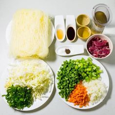 an assortment of food on plates with chopsticks and sauces next to them