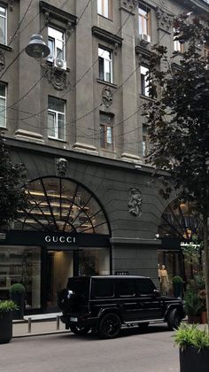 a black suv parked in front of a building