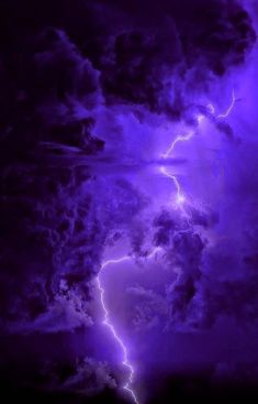 a purple storm with lightning striking through the sky