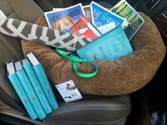 books are sitting in the back seat of a car with a green ribbon on it