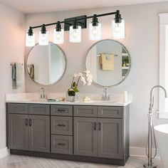 a bathroom with double sinks and two mirrors on the wall next to eachother