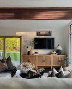 a living room filled with furniture and a flat screen tv mounted to the side of a wall