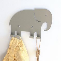 an elephant shaped coat rack hangs on the wall next to a yellow and white checkered cloth