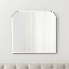 a couch with a mirror on the wall above it