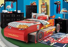 a child's bed with cars printed on the sheets and pillow cases in red