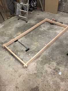 an unfinished frame sitting on the ground in a garage