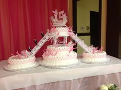 three tiered wedding cakes with pink bows and ribbons are on a white table cloth