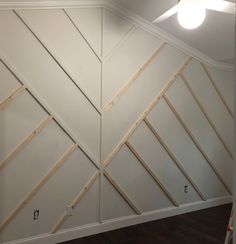 an unfinished room with white walls and wood trimmings on the wall, along with a ceiling fan