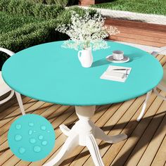 a blue table and white chairs on a wooden deck next to a flower vase with baby's breath in it