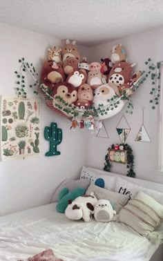 a bed with stuffed animals on the headboard and hanging decorations above it in a bedroom