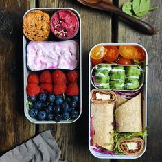 two tins filled with food sitting on top of a wooden table next to each other