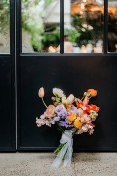 a bouquet of flowers sitting in front of a black door