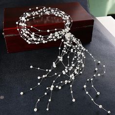 a white beaded headpiece on a wooden box