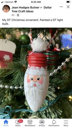 a christmas ornament hanging from a tree with santa's face on it