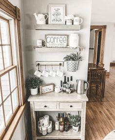 a coffee bar in the corner of a room with two shelves and cups on it