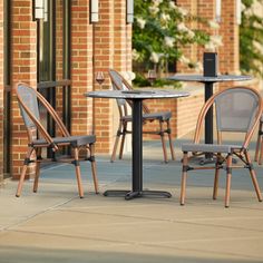 three chairs and a table on the sidewalk