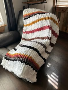 a blanket sitting on top of a couch next to a window