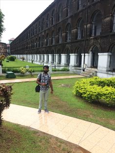 a man standing in front of a building with lots of windows on it's side