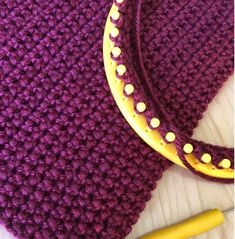 a purple crocheted bag next to a yellow marker