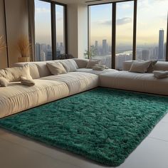 a living room with large windows and a green rug on the floor in front of it