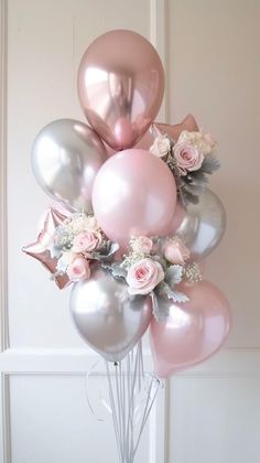 a bunch of pink and silver balloons are in a vase with some flowers on it