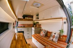 the interior of a tiny house with wood flooring and white walls, including a couch