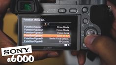 a person holding up a camera with the words sony on it in front of them