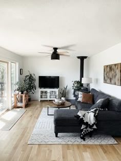 a living room filled with furniture and a flat screen tv on top of a wooden floor