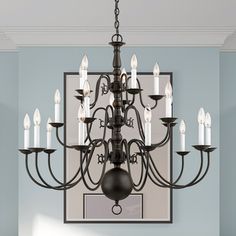 a chandelier hanging from the ceiling in a room with blue walls and white candles